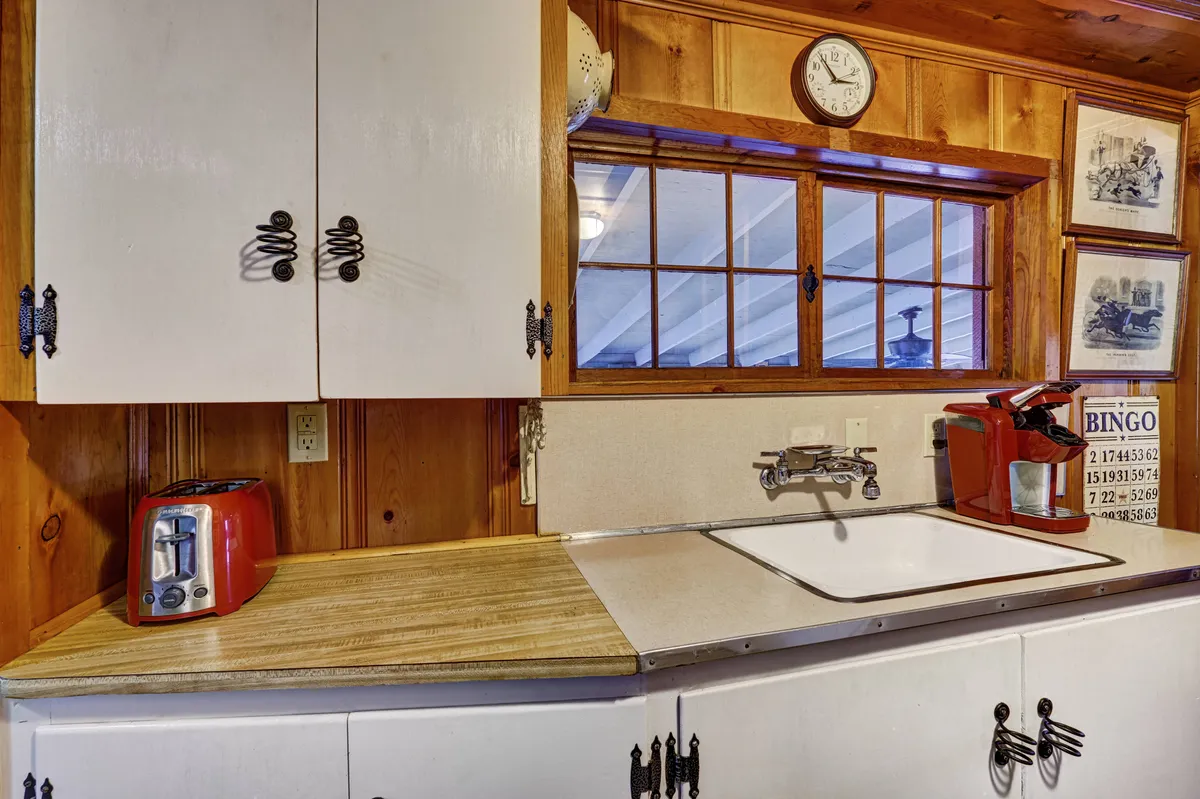 Here, wooden cabinets and a kitchen sink come together with visible kitchen appliances, creating a homey scene ideal for meal preparation or gatherings. The atmosphere is inviting, making it easy to imagine sharing breakfast or preparing a favorite family recipe.